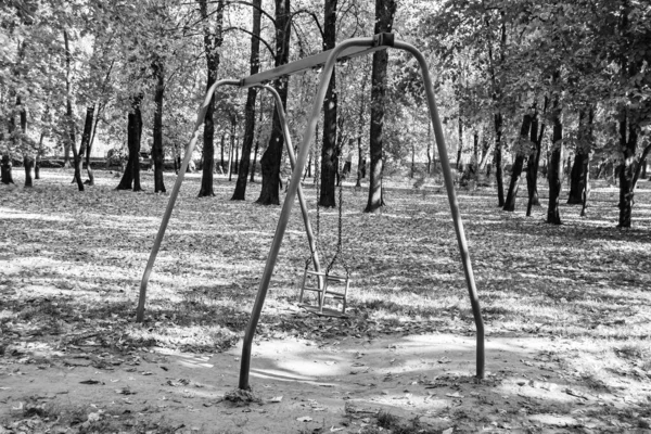Photography on theme empty playground with metal swing for kids on background natural nature, photo consisting from playground with steel swing, swing on old playground in countryside without people