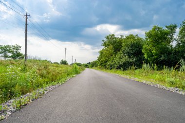Renkli arka planda güzel boş asfalt yol, kırsal alandan geçen yeni boş asfalt yol, yeşillik kırsalında hız arabası için boş asfalt yol.
