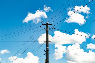 Renkli arka planda kablo olan elektrik direği yakın planda, elektrik direği ile gökyüzünün altında halat kablosu, konut binaları için elektrik direği hattı kablosu.