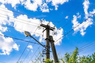 Renkli arka planda kablo olan elektrik direği yakın planda, elektrik direği ile gökyüzünün altında halat kablosu, konut binaları için elektrik direği hattı kablosu.