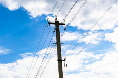 Renkli arka planda kablo olan elektrik direği yakın planda, elektrik direği ile gökyüzünün altında halat kablosu, konut binaları için elektrik direği hattı kablosu.