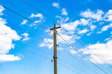 Renkli arka planda kablo olan elektrik direği yakın planda, elektrik direği ile gökyüzünün altında halat kablosu, konut binaları için elektrik direği hattı kablosu.