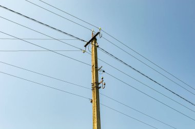 Renkli arka planda kablo olan elektrik direği yakın planda, elektrik direği ile gökyüzünün altında halat kablosu, konut binaları için elektrik direği hattı kablosu.