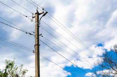 Renkli arka planda kablo olan elektrik direği yakın planda, elektrik direği ile gökyüzünün altında halat kablosu, konut binaları için elektrik direği hattı kablosu.