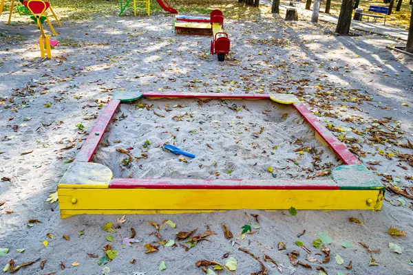 背景の遊び場の子供のための砂とテーマの空の木製のサンドボックスの写真 穀物の砂と正方形のサンドボックスから構成される写真 田舎の古いサンドボックスで人々なし — ストック写真