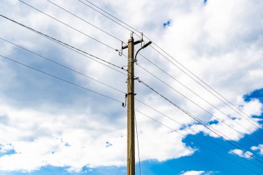 Renkli arka planda kablo olan elektrik direği yakın planda, elektrik direği ile gökyüzünün altında halat kablosu, konut binaları için elektrik direği hattı kablosu.