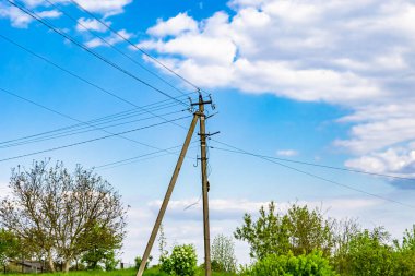 Renkli arka planda kablo olan elektrik direği yakın planda, elektrik direği ile gökyüzünün altında halat kablosu, konut binaları için elektrik direği hattı kablosu.