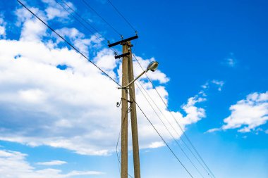 Renkli arka planda kablo olan elektrik direği yakın planda, elektrik direği ile gökyüzünün altında halat kablosu, konut binaları için elektrik direği hattı kablosu.