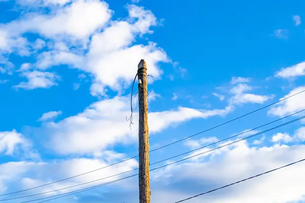 Renkli arka planda kablo olan elektrik direği yakın planda, elektrik direği ile gökyüzünün altında halat kablosu, konut binaları için elektrik direği hattı kablosu.