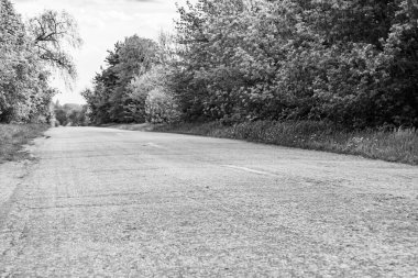 Koyu arkaplanda güzel boş asfalt yol, kırsal alandan geçen yeni boş asfalt yol, yeşillik kırsalında hız arabası için boş asfalt yol.