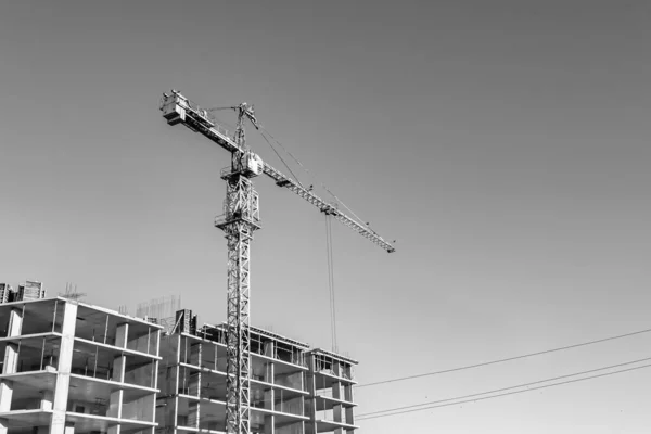 Big steel crane on construction site of residential building, photo consisting of large crane at construction site of residential building, high crane to construction site of residential building