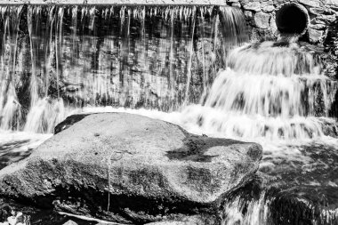 Tema üzerine fotoğraf. Bahçe şelalesinden güzel bir sonbahar suyu, doğal doku yakın, doğa bahçesi şelalesi ile berrak su içeren bir fotoğraf, uzun şelaleden hızla akan su.