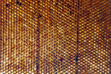 Altın nektarla dolu altıgen bal peteklerinden arı damlayan bal damlası, bal peteği yaz kompozisyonu doğal bal damlası, balmumu çerçeve arısına damlayan bal damlası, bal peteğine damlayan bal damlası