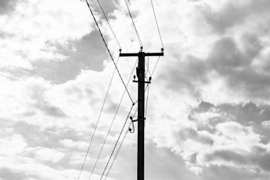 Karanlık arka planda elektrik teli olan elektrik direği yakın planda, elektrik direği ile gökyüzünün altındaki halat teli, konut binaları için elektrik direğine bağlı halat teli içeren fotoğrafçılık.