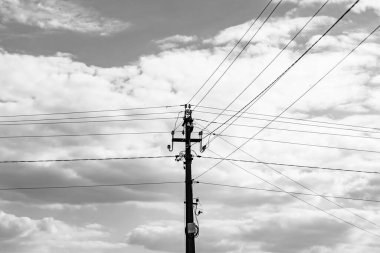 Karanlık arka planda elektrik teli olan elektrik direği yakın planda, elektrik direği ile gökyüzünün altındaki halat teli, konut binaları için elektrik direğine bağlı halat teli içeren fotoğrafçılık.