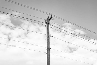 Karanlık arka planda elektrik teli olan elektrik direği yakın planda, elektrik direği ile gökyüzünün altındaki halat teli, konut binaları için elektrik direğine bağlı halat teli içeren fotoğrafçılık.