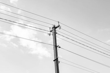 Karanlık arka planda elektrik teli olan elektrik direği yakın planda, elektrik direği ile gökyüzünün altındaki halat teli, konut binaları için elektrik direğine bağlı halat teli içeren fotoğrafçılık.