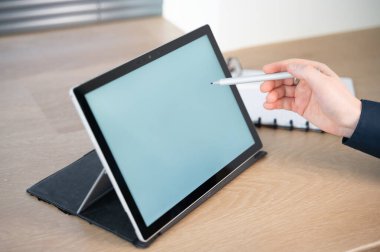 Dokunmatik ekran tabletinde stil kullanan bir birey gelişmiş dijital çalışma alanı teknolojisi sergiliyor.