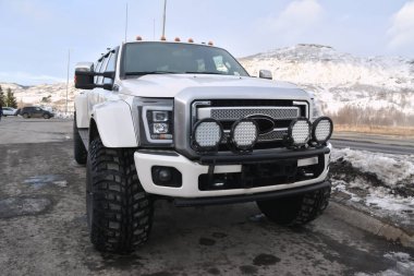 Özellikle off-road performansı için tasarlanmış ve güçlü spot ışıklarıyla donatılmış engebeli, kaldırılmış bir kamyon.