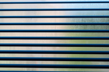 Bu resim, onların dokusu ve tasarımı hakkında detaylı bir görüş sağlayan, panjurlarla donatılmış bir pencerenin detaylı bir yakın çekimini içerir.