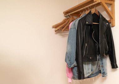 Moda çok yönlülüğünü gösteren ahşap bir askıda yaratıcı bir şekilde sergilenen moda bir ceket koleksiyonu.