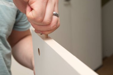 Tahtaya ustalıkla oturtulmuş bir el, mobilya montajında maharetli işçilik sergiliyor.