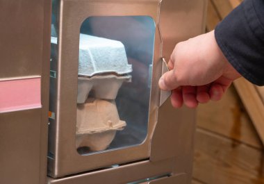 Bir insan eli, çeşitli yumurtalarla dolu bir kutuya dikkatlice uzanır ve içindekilerle etkileşimi gösterir.