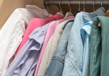 Askılara yerleştirilmiş canlı bir gömlek koleksiyonu, çeşitli renkler ve stiller sergileniyor..