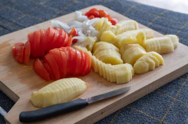 Taze dilimlenmiş domates ve patateslerden oluşan çok güzel bir düzenleme. Yemek ve salata hazırlığı için hazır.