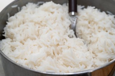 Pofuduk beyaz pirinçle dolu dumanı tüten bir kase. Yemek ve yemek hazırlıklarını tamamlamak için birebirdir.