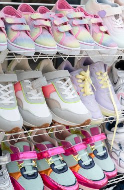 Moda ve şık çocuk spor ayakkabıları koleksiyonu, izlemek için zarif bir askıda sergileniyor.