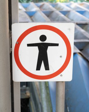 Güvenlik gerekçesiyle girişi yasaklanmış bir bölgeyi işaret eden uyarı işareti, bir insan figürü sembolü içeriyor