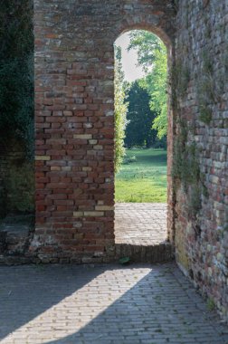 Huzurlu ve huzurlu bir manzara güzel eski bir tuğla kemer yolu boyunca, her yerde yemyeşil sergileniyor.