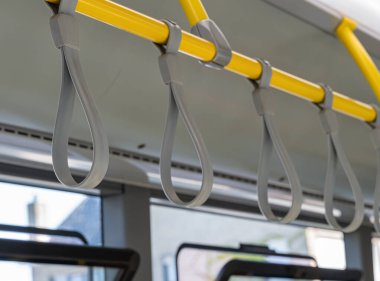 Seyahatler sırasında banliyö güvenliği ve konforu için toplu taşıma aracındaki sağlam sarı askıların yakınlaştırılması