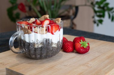 Yoğurt, çilek ve granolaya katılmış canlı chia tohumu parfe 'nin tadını çıkarın. Mükemmel kahvaltı ya da atıştırmalık.