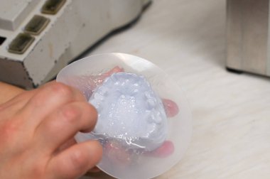 Yetenekli bir el, şeffaf materyali özel bir yaprak ile şekillendirir.