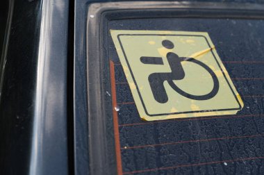 Özürlü park sembolü etiketinin kimlik tespiti için arabanın camına yapıştırılmış ayrıntılı bir yakın plan görüntüsü