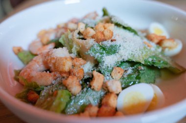 Kıtır marul, kıtır kıtır kıtır kızarmış ekmek rendelenmiş parmesan peyniri ve haşlanmış yumurta içeren canlı yeşil bir salata. Hafif bir yemek için mükemmel..