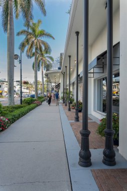 İnsanlar Napoli, Florida 'da 5. Cadde' de vitrinlere bakıyorlar. Butiklerle, vitrinlerle ve tropikal açık hava atmosferiyle hareketli bir alışveriş bölgesi..