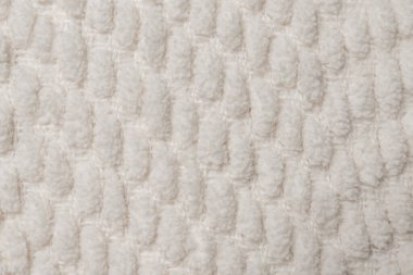 Yumuşak bej tabanlı ve parlak lifli dekoratif örgü kumaş yakın çekim. Konforlu ve desenli yüzey soyut arkaplan ya da tekstil tasarımı için mükemmel. 