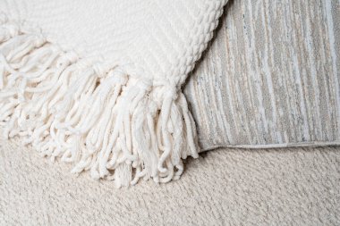 Yumuşak desenli yastıklarda fırfırlar olan nötr renkli battaniye. Konforlu ev dekorasyonu, iç dekorasyon veya tekstil ve kumaş tasarım temaları için mükemmel. 