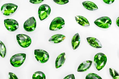 Beyaz arka planda sıralanmış yeşil değerli taşlar koleksiyonu. Tasarım, dekorasyon veya yaratıcı projeler için yüksek çözünürlüklü makro fotoğrafçılık. 