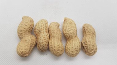a high angle shot of a pile of peanuts on a white surface