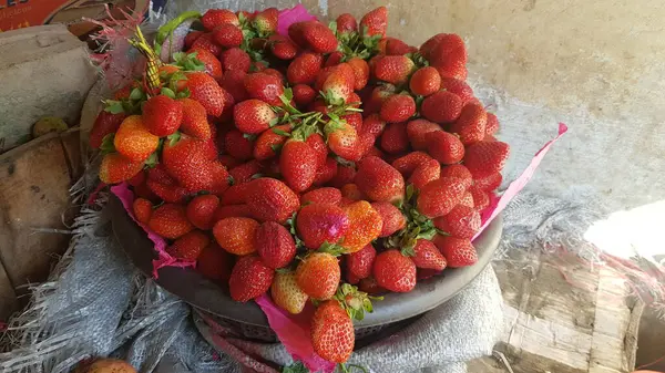 Tahta arka planda olgun taze çilekler..