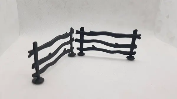 Metal saplı ahşap bir çitin siyah beyaz fotoğrafı.