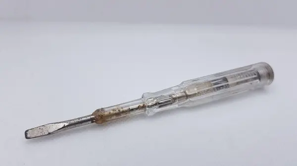 Beyaz arka planda paslı metal tornavida.