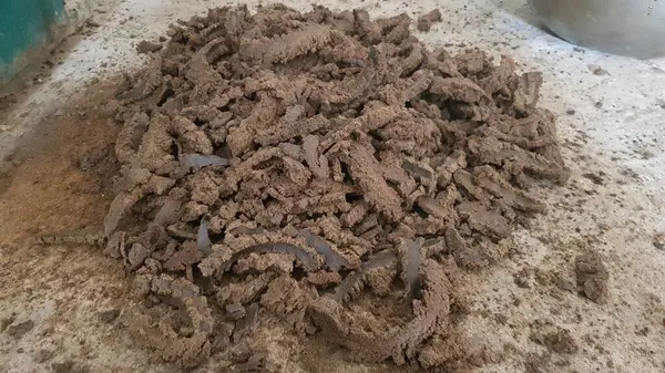 Kuru bir toprak yığını ve arka planda tahta bir kaşık yakın plan çekimi.