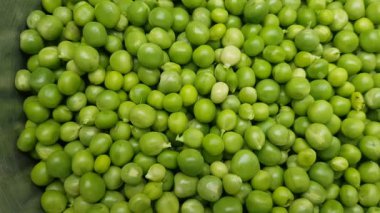 Beyaz bir tabak içinde yeşil bezelye