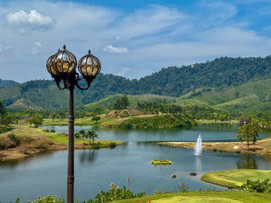 Göllü ve yeşil tepeli klasik sokak lambası.