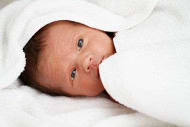 Bebek beyaz battaniyenin altında saklanıyor. Yüksek kalite fotoğraf